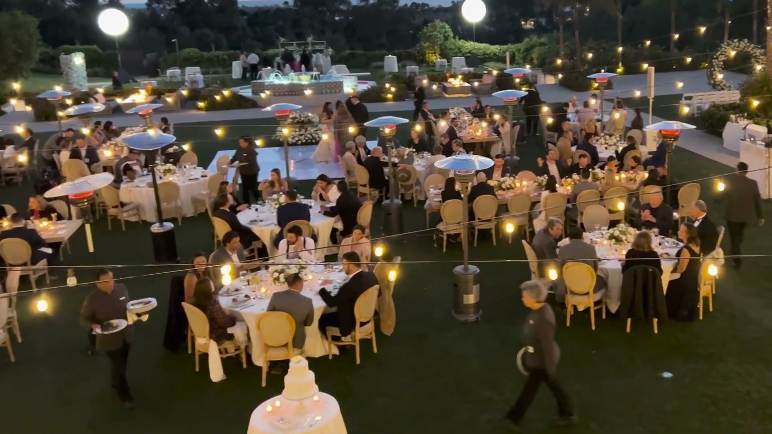 Twilight garden reception at Park Hyatt Aviara with string lights, lawn tables, and a sunset sky